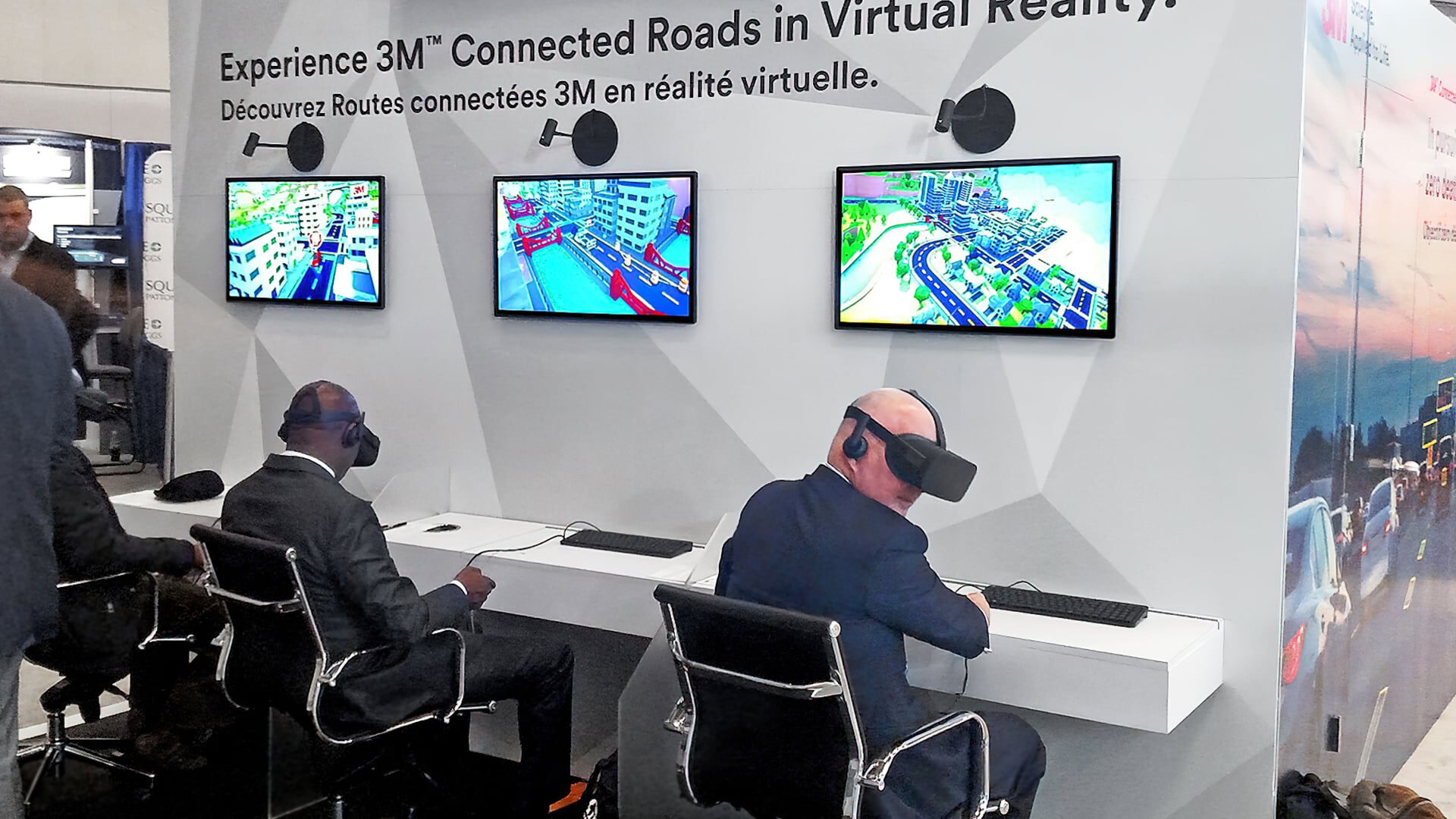 Two men in suits experience virtual road simulations with VR headsets.
