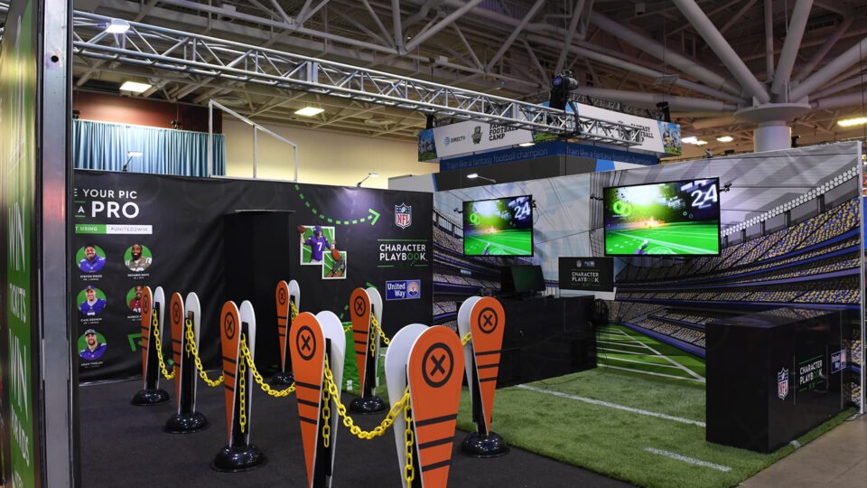NFL interactive exhibit with virtual football gameplay and player selection booths.