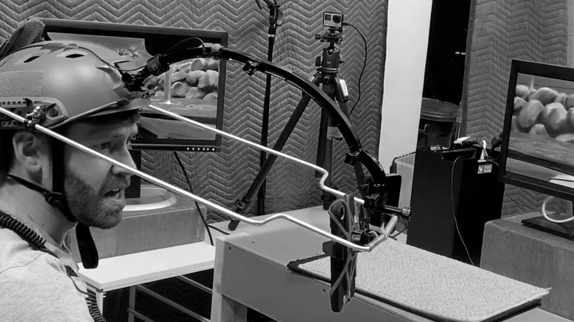 Man wearing motion capture gear in a studio with monitors