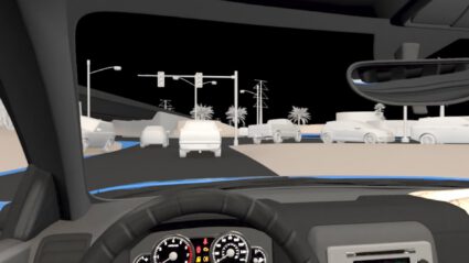 Nighttime driving view from inside car, showing traffic lights and road ahead.