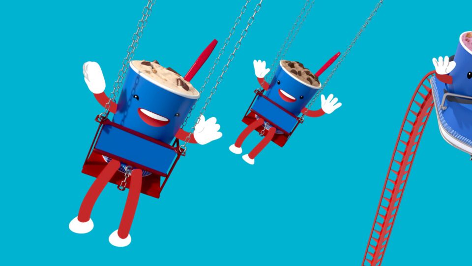 Three cheerful Dairy Queen Blizzard cup characters on a red roller coaster against a blue background.