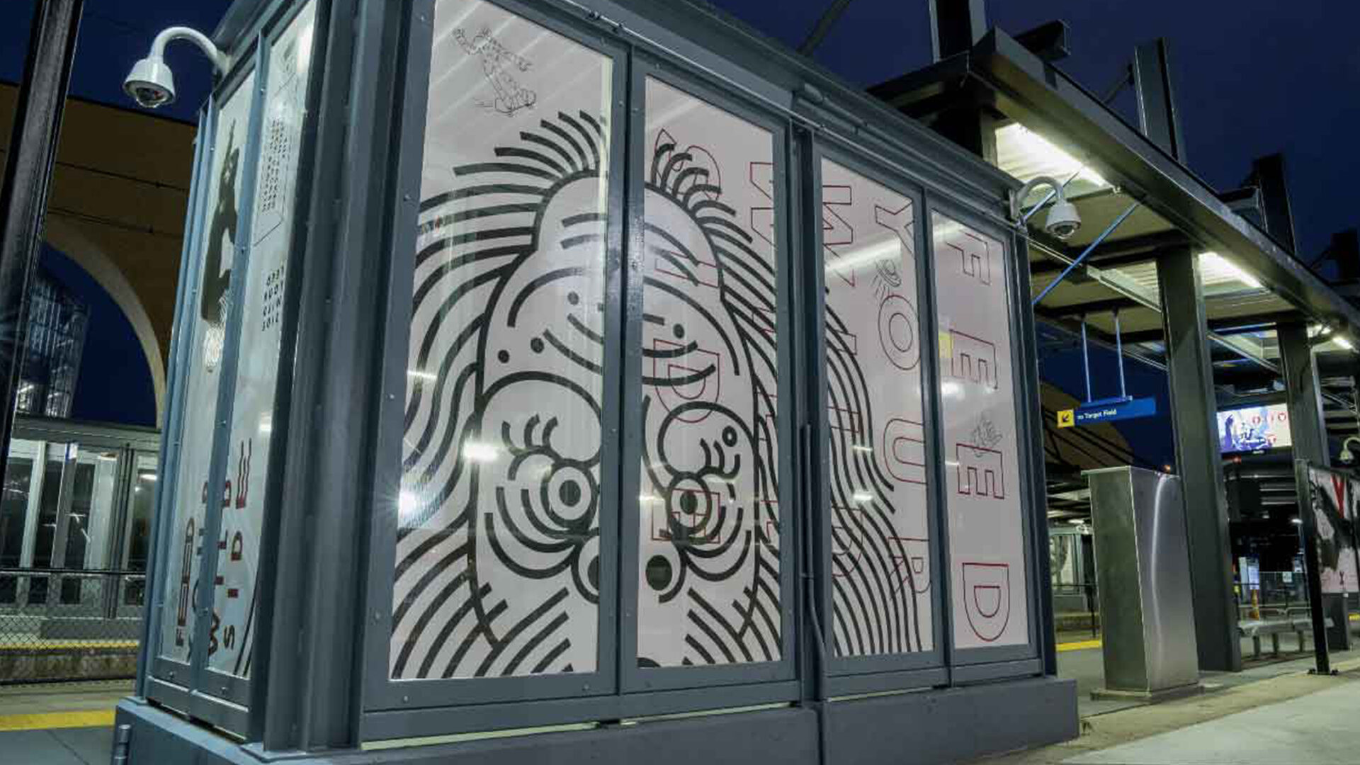 Artistic station kiosk with stylized face design and bold typography