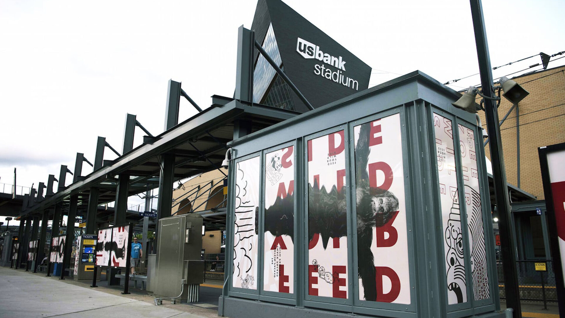 U.S. Bank Stadium exterior with bold graphic art on ticket booth panels.