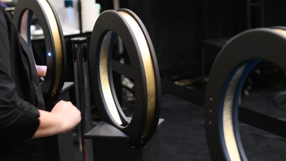 Person adjusting a circular light display at an exhibition