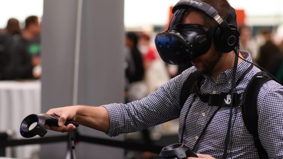 Man using VR headset and controllers at a tech event
