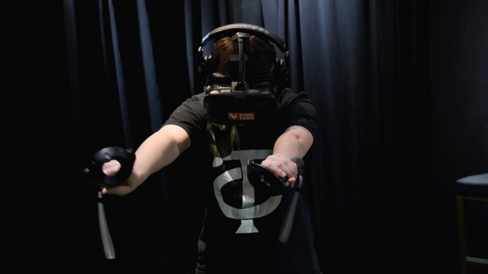 Person in VR headset using controllers in dark room