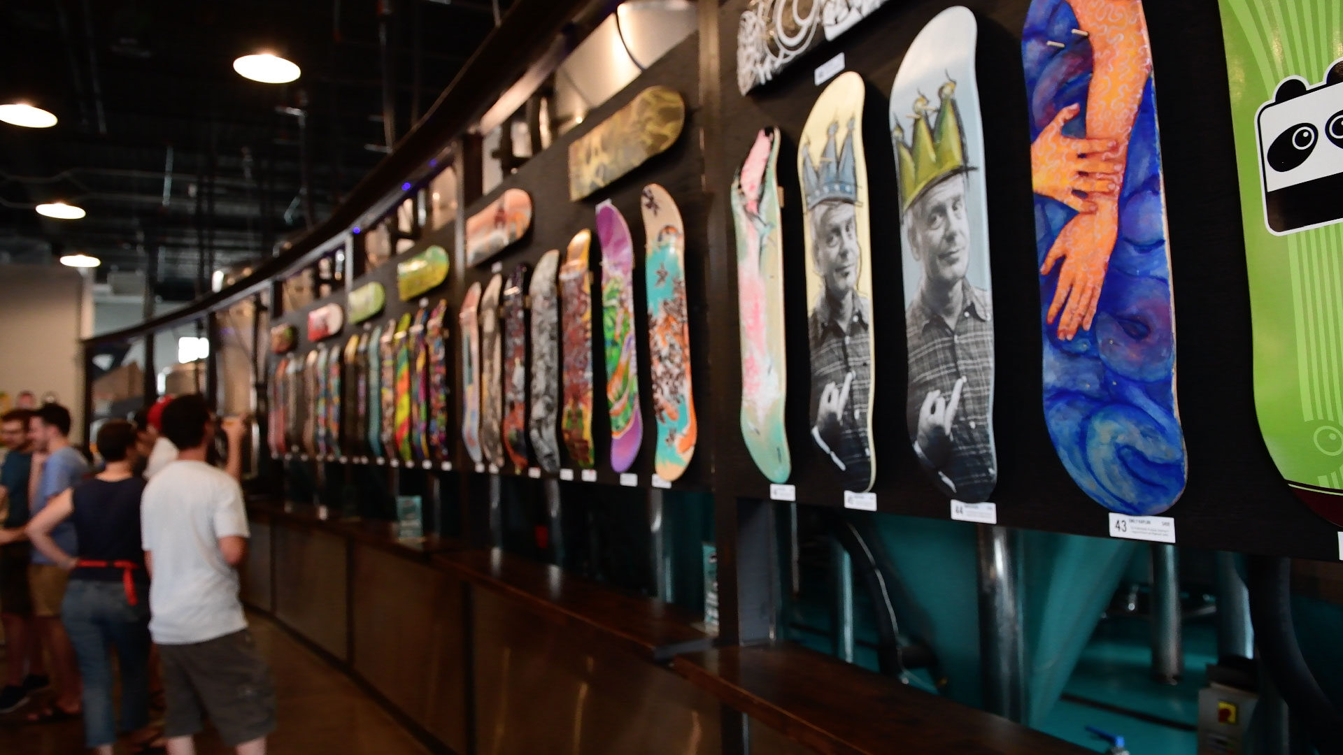 Wall display of colorful, artistically designed skateboards in a shop or gallery.