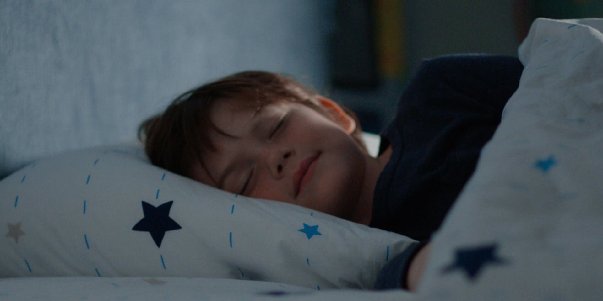 Young child peacefully asleep on star-patterned pillow