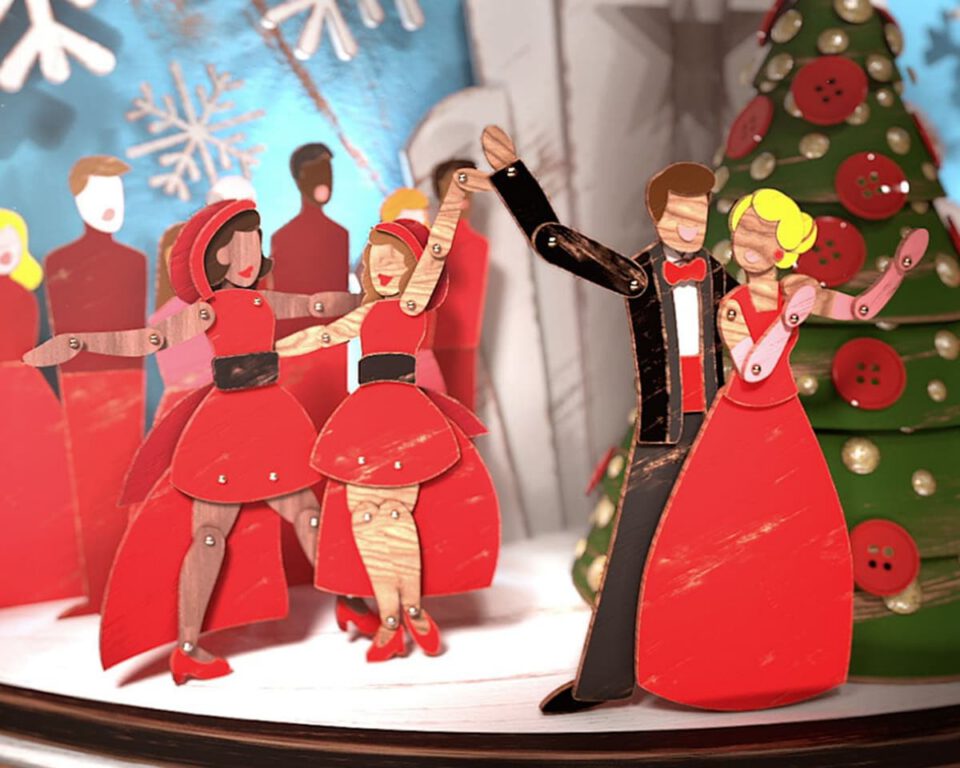 Paper cutout dancers in red gowns and tuxedo perform festive Christmas dance