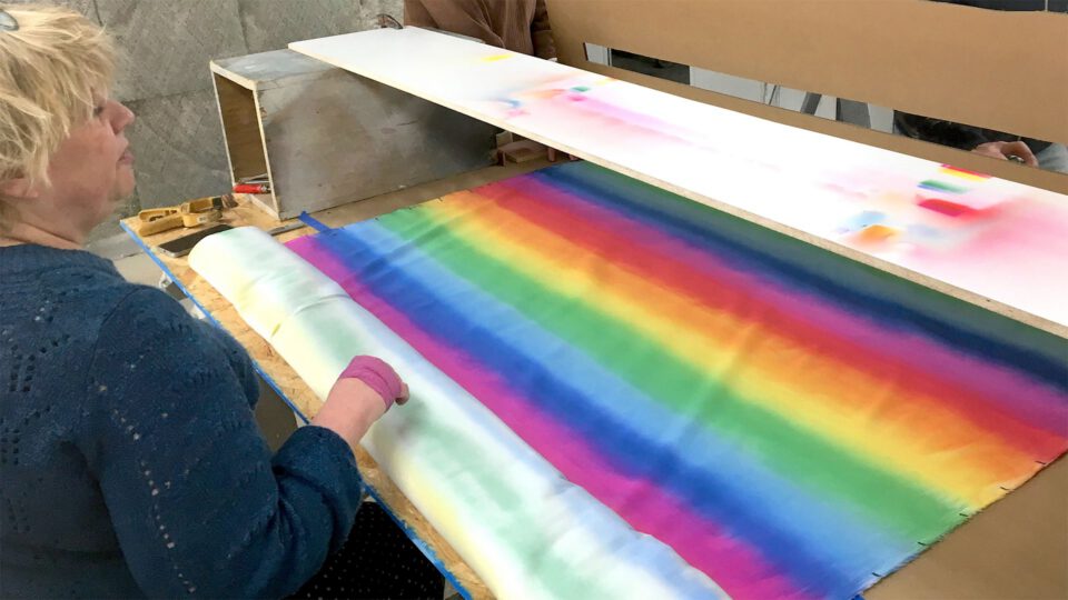Artist creates rainbow fabric using dye techniques in workshop setting