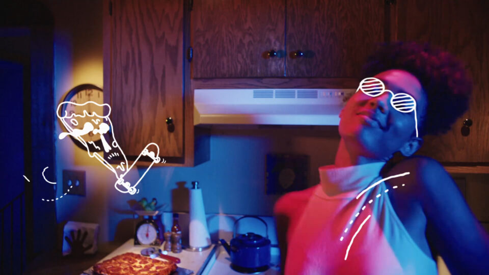 Person in kitchen wearing neon sunglasses, with animated pizza slice graphic nearby.