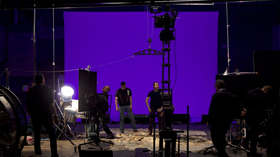 Film crew shoots scene against purple chroma key backdrop