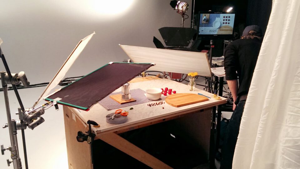 Studio food shoot with lighting, props, and crew in background