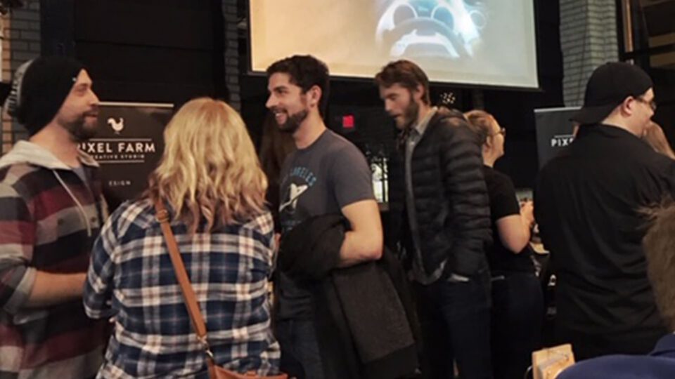 Group of people at Pixel Farm event, some facing camera, others turned away