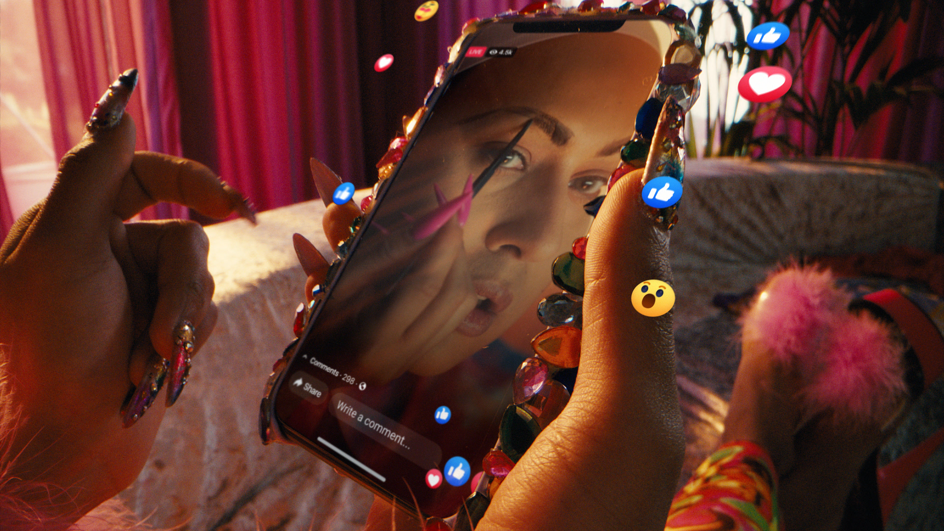 Person with decorated nails holds phone showing social media video with engagement icons.