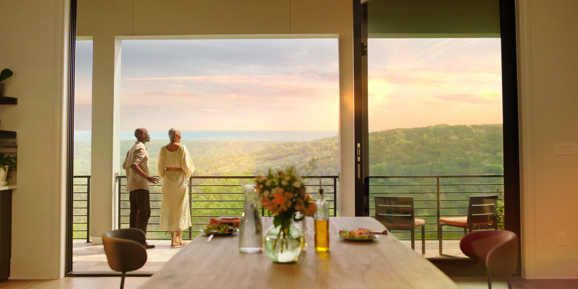 Elderly couple enjoys scenic sunset view from modern home balcony