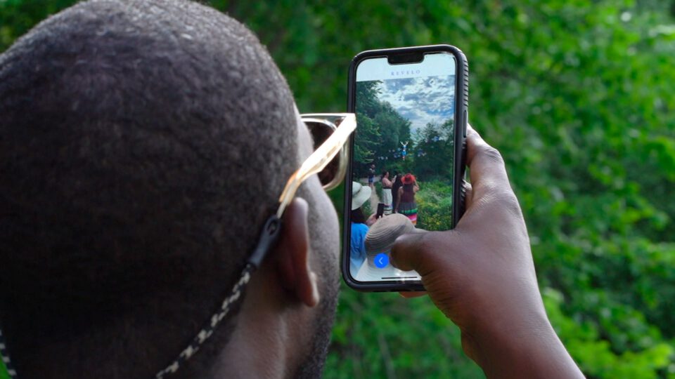 Person using the Revelo Augmented reality app outdoor group with smartphone