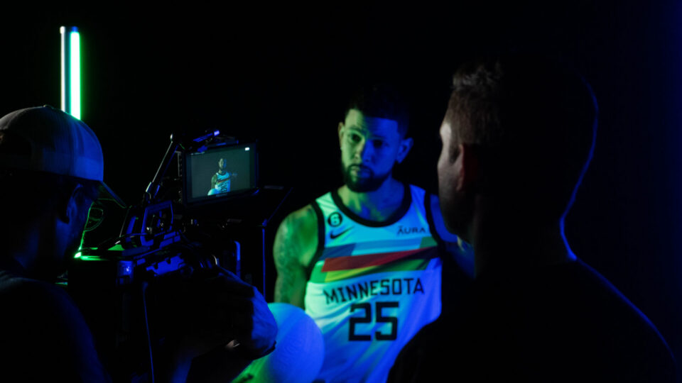 Basketball player #25 in Minnesota jersey filmed on set with crew
