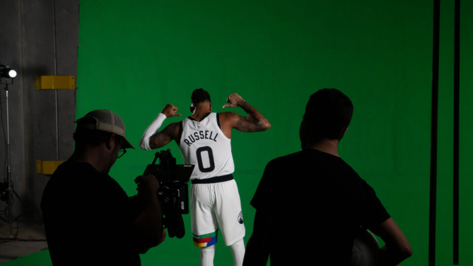 Basketball player in white jersey posing on green screen set