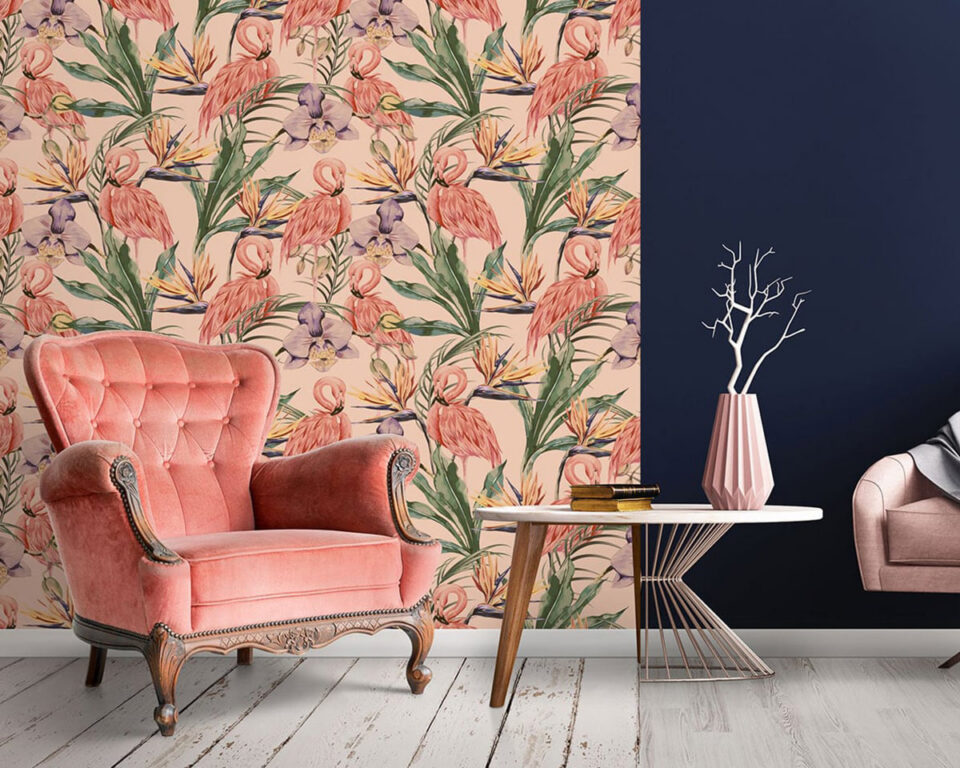 Vintage pink armchair beside tropical wallpaper and modern side table.