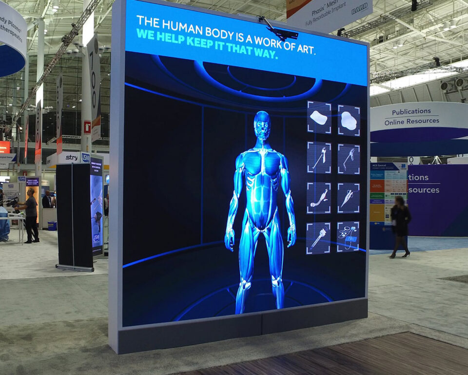 Medtronic digital event display showing a blue human body model with medical tools, promoting body preservation.