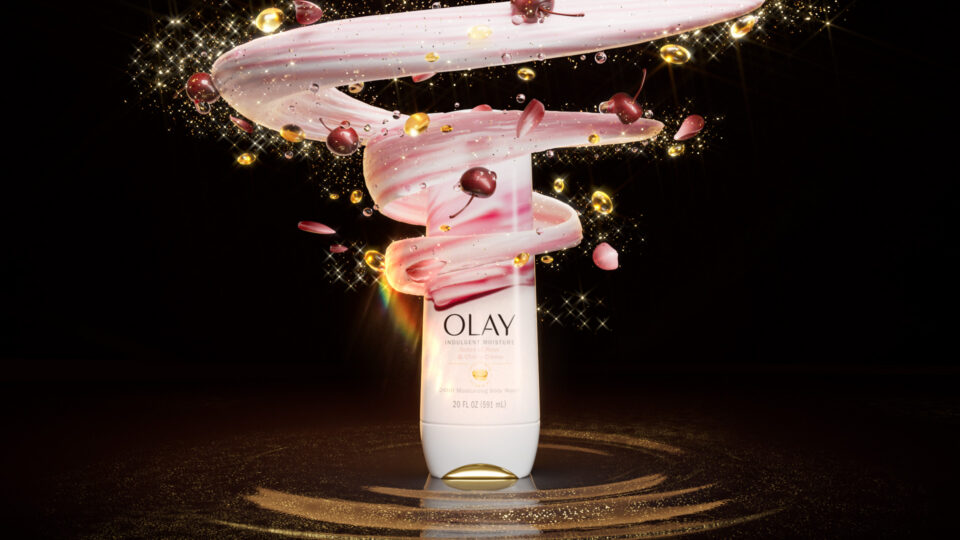 Olay cream swirls with cherries and glitter against a dark background