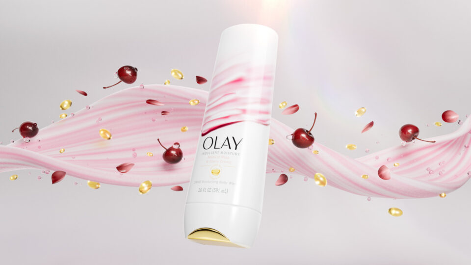 Olay cream bottle with cherry-themed swirls and floating fruit