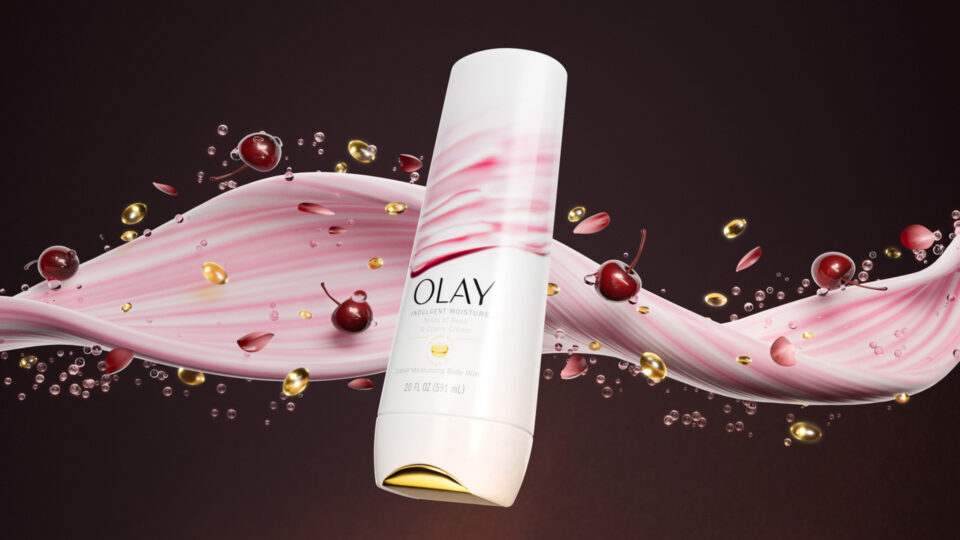 Olay moisturizer bottle with cherry-themed swirling design and droplets