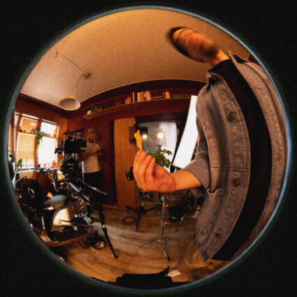 Person holding snack in fisheye shot of busy film set room