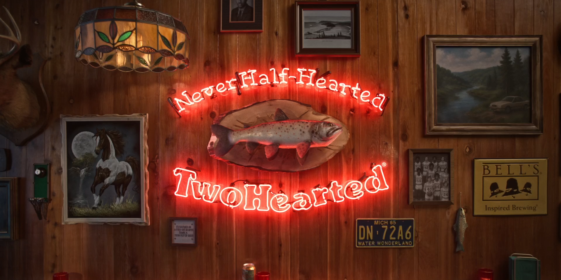 Neon sign reads "Never Half-Hearted Two Hearted" with fish mounted above.