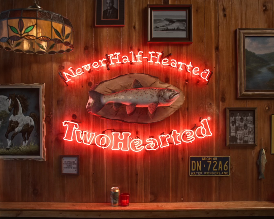 Neon sign reads "Never Half-Hearted Two Hearted" with fish mounted above.